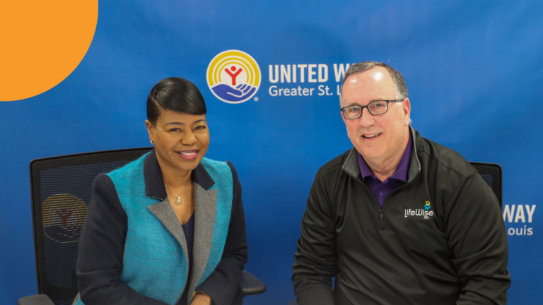 CEO and President of United Way Michelle Tucker and Scott Walker of LifeWise STL sitting down at a table looking at the camera.