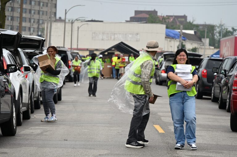 The image shows a line of cars being served by volunteers and nonprofit organizations - an important part of recovery.
