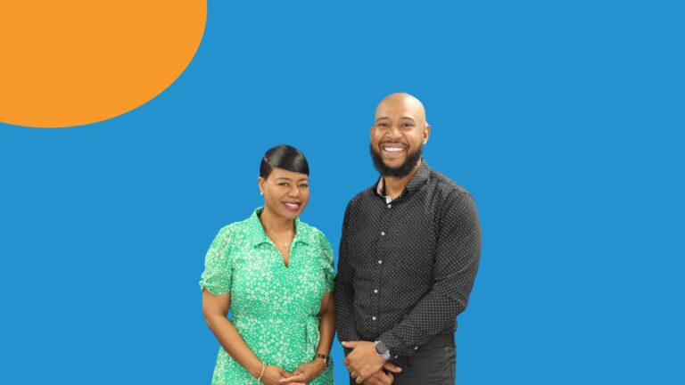 Michelle Tucker, President and CEO of UWGSL and Christopher Williams, Executive Director of Eagle’s Nest of St. Clair County stand together smiling in front of a blue background
